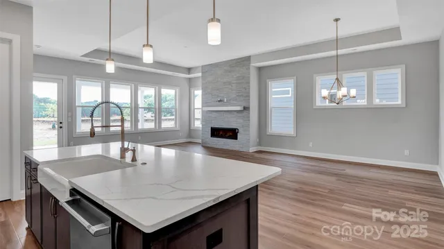 a dining room with wooden floor a chandelier a wooden table and chairs