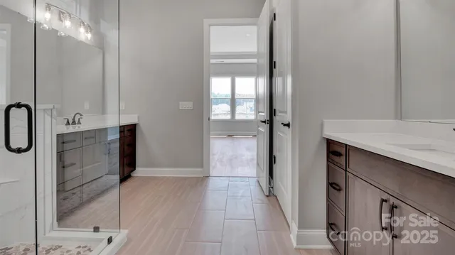 a bathroom with a granite countertop sink a mirror and shower