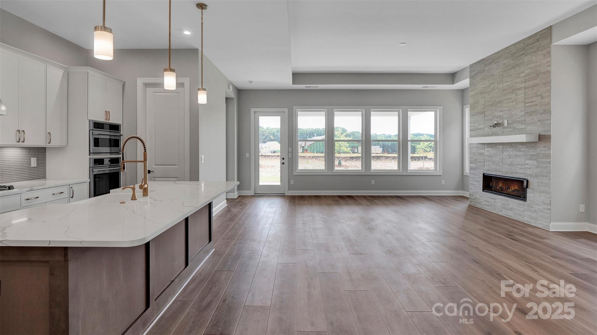 1031 Rabbit Hl Lane Monroe, NC 28110 - Photo 23 of 47 a large kitchen with stainless steel appliances a large counter top a stove a sink dishwasher and a fireplace with wooden floor