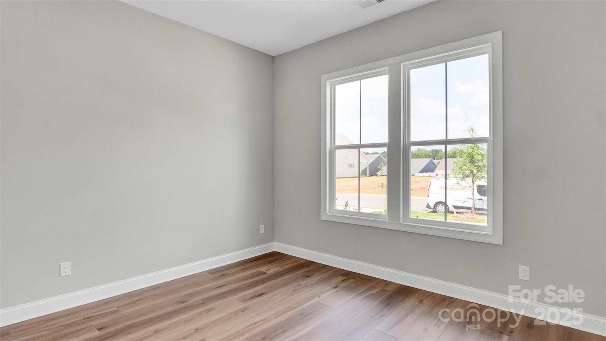 1031 Rabbit Hl Lane Monroe, NC 28110 - Photo 30 of 47 a view of an empty room with wooden floor and a window