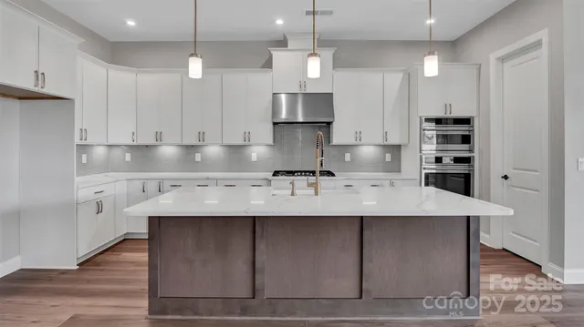 a kitchen with kitchen island granite countertop a sink a center island and cabinets