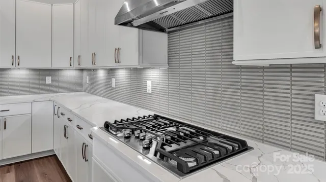 a kitchen with a stove and white cabinets