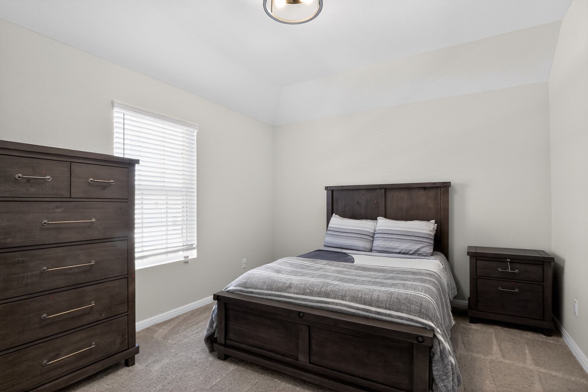 114 Bosco Road Hutto, TX 78634 - Photo 30 of 39 A comfortable bedroom features plush carpeting and a contemporary ceiling light fixture.