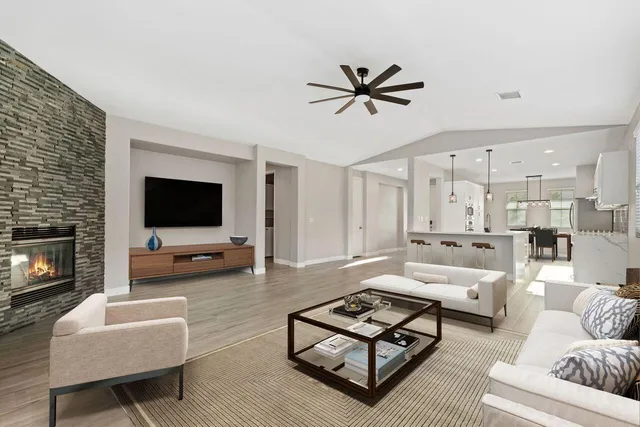 a living room with furniture a flat screen tv and a fireplace