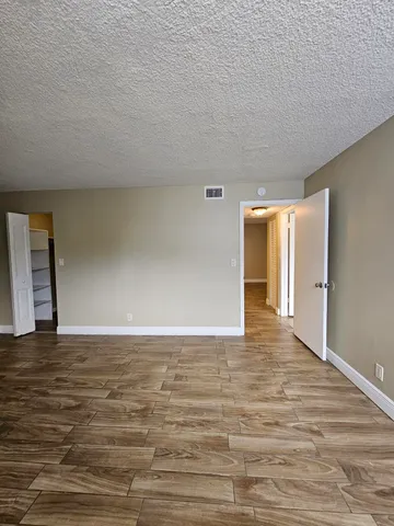 a view of an empty room with wooden floor