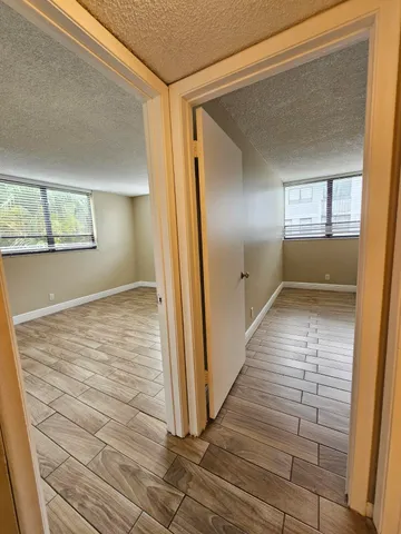 a view of a hallway with wooden floor and staircase