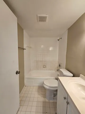 a bathroom with a granite countertop sink a toilet and shower