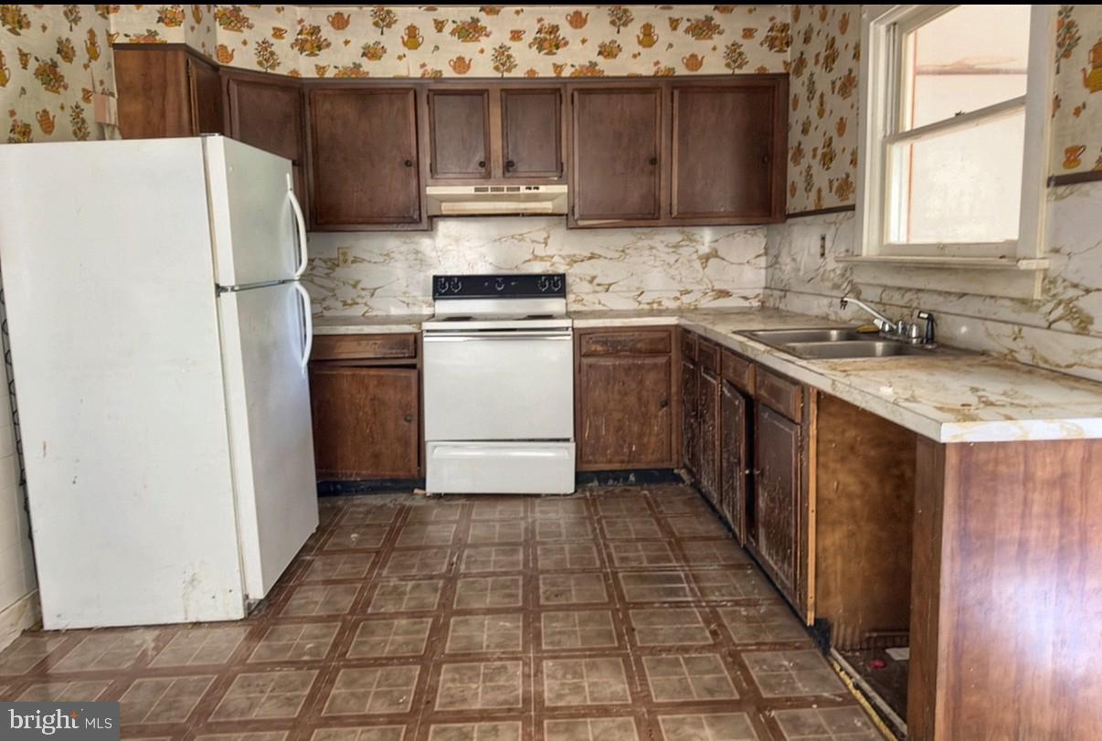 115 North Marshall Street Shamokin, PA 17872 - Photo 13 of 22 a kitchen with a refrigerator a stove a sink and cabinets