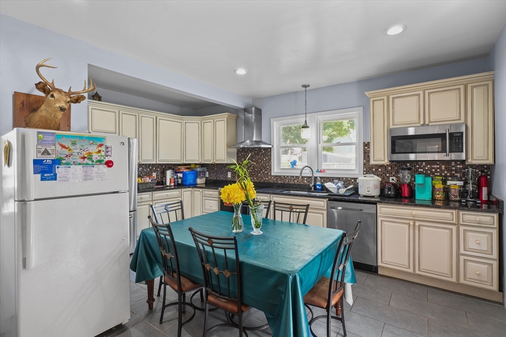 81 5th Avenue Lowell, MA 01854 - Photo 11 of 35 a kitchen with refrigerator cabinets dining table and chairs