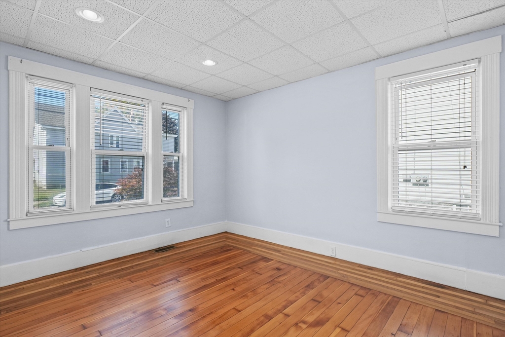 81 5th Avenue Lowell, MA 01854 - Photo 5 of 35 an empty room with wooden floor and windows