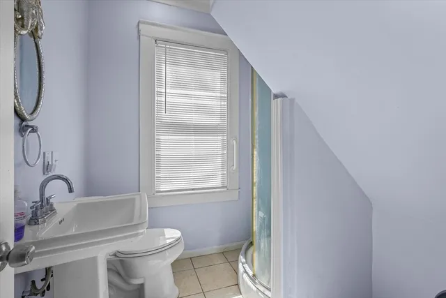 a bathroom with a toilet a sink and a window