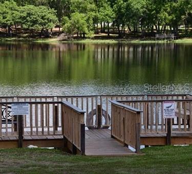 2092 Culbreath Road, Unit C52 Brooksville, FL 34602 - Photo 29 of 33 a view of a wooden deck with lake and next to house