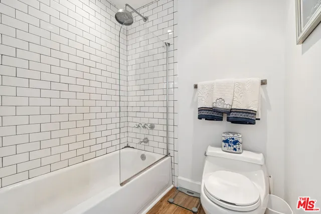 a bathroom with a toilet a sink a mirror and bathtub