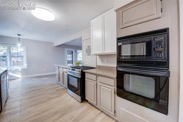 a kitchen with stainless steel appliances kitchen island granite countertop a stove a microwave and a hard wood floors