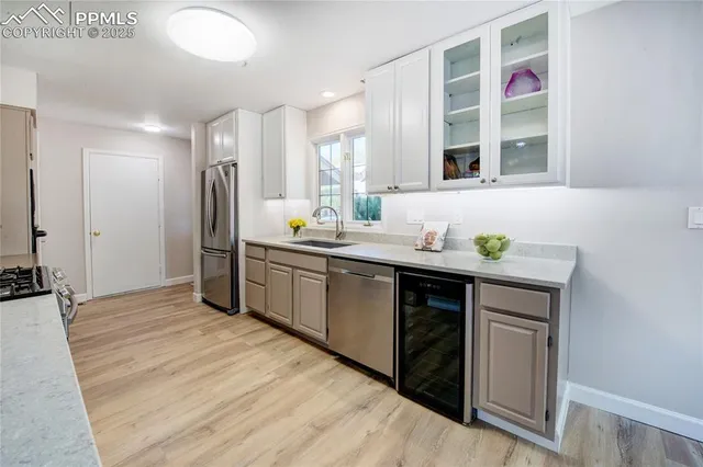a kitchen with stainless steel appliances a sink cabinets and wooden floor