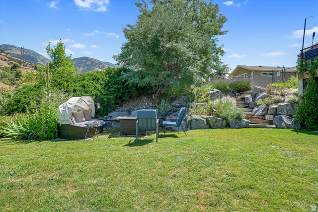 510 Spring Creek Road Providence, UT 84332 - Photo 79 of 97 Expansive grassy yard with tiered rock landscaping and natural wood steps