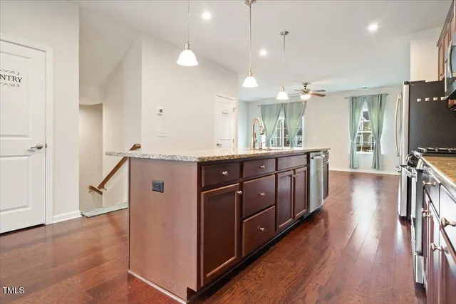a kitchen with a sink a counter top space and stainless steel appliances