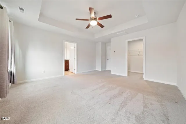 an empty room with ceiling fan and window