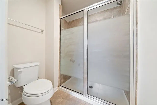 a white toilet next to a bathroom