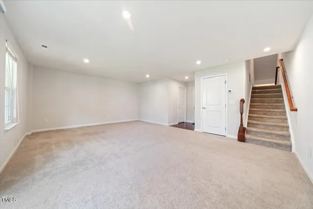an empty room with windows and stairs