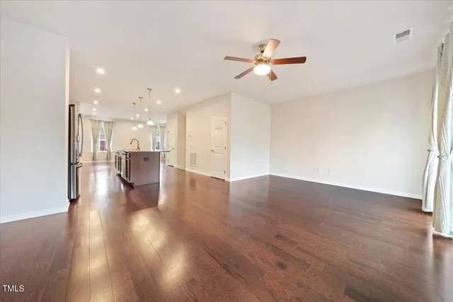 a view of empty room with wooden floor and window