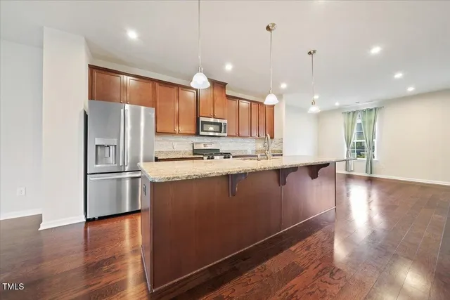 a kitchen with stainless steel appliances a refrigerator sink and microwave