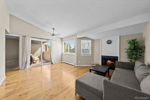 a living room with furniture and a dining table with wooden floor
