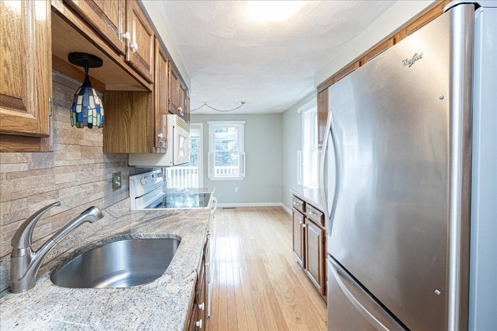 22 Collins Street, Unit 46 Danvers, MA 01923 - Photo 15 of 37 a kitchen with granite countertop a sink and a refrigerator