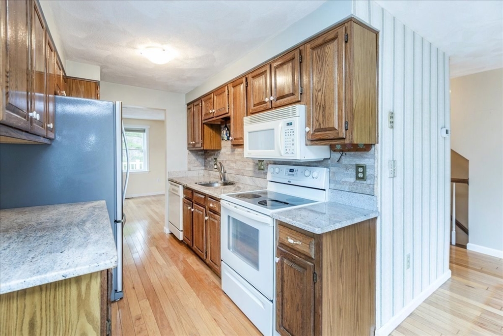 22 Collins Street, Unit 46 Danvers, MA 01923 - Photo 17 of 37 a kitchen with stainless steel appliances granite countertop a sink stove cabinets and wooden floor
