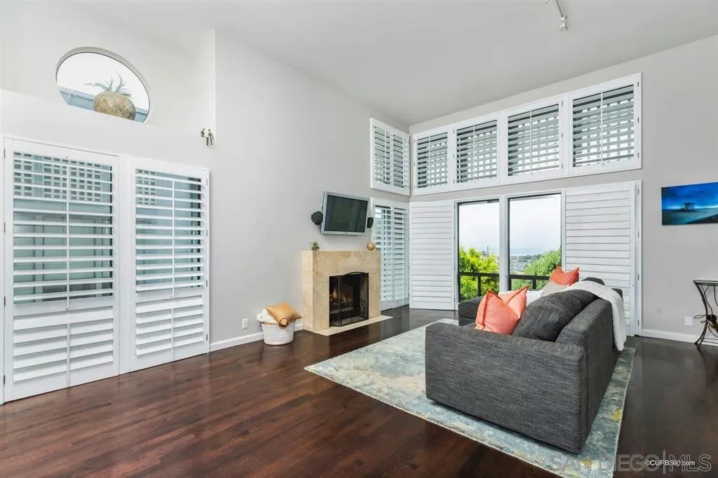 a living room with furniture a fireplace and a large window