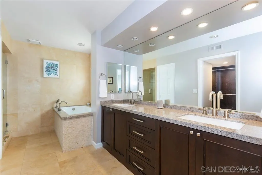 1031 America Way Del Mar, CA 92014 - Photo 16 of 25 a bathroom with a granite countertop double vanity sink a mirror and a bathtub