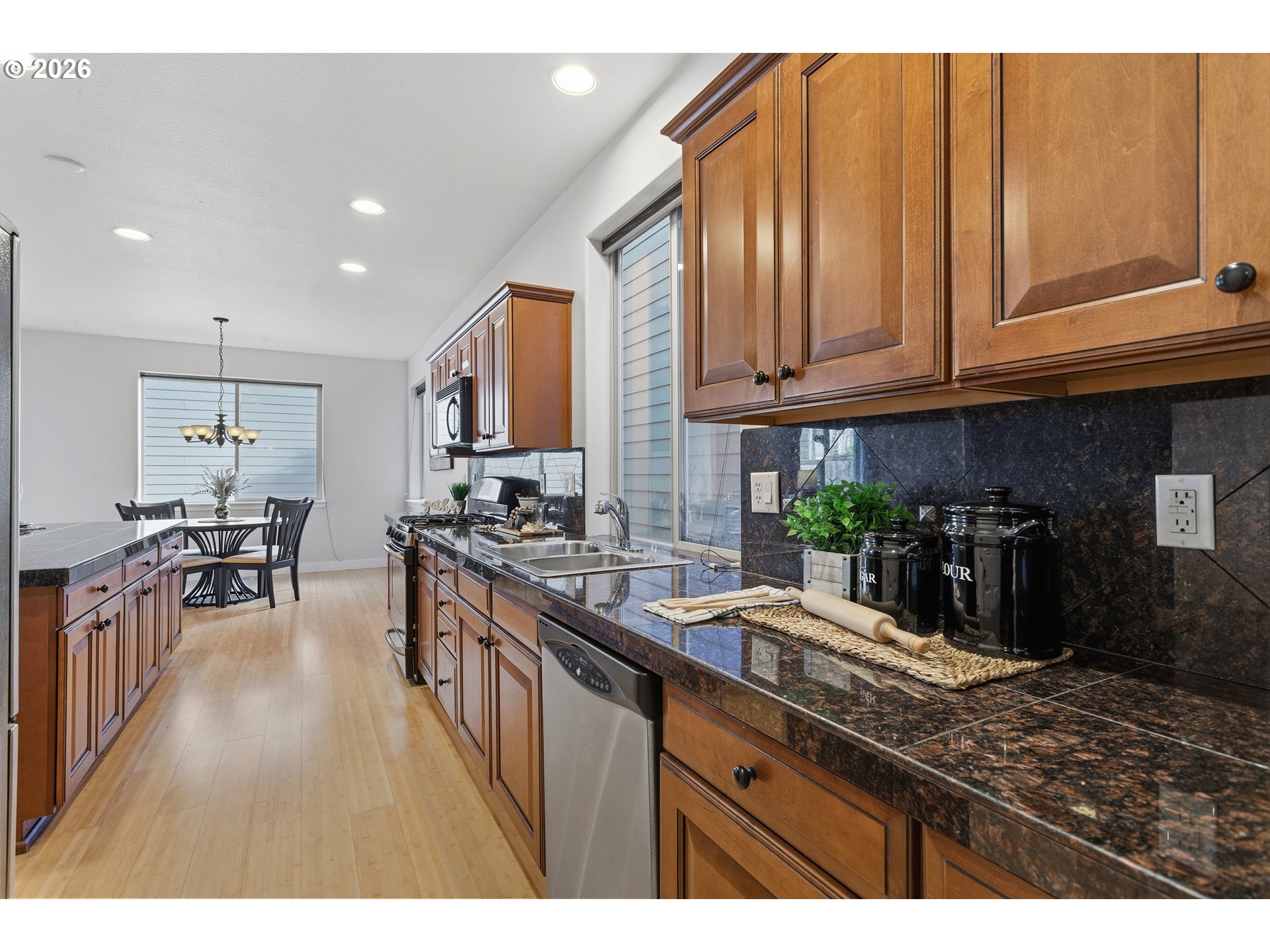 2502 Northwest Parnell Terrace Portland, OR 97229 - Photo 17 of 48 a kitchen with stainless steel appliances granite countertop a stove a sink dishwasher and cabinets with wooden floor