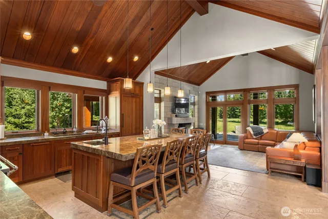 a view of a dining room with furniture large windows and a chandelier
