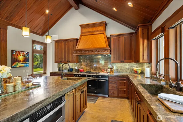 a kitchen with kitchen island granite countertop a sink a counter top space appliances and cabinets
