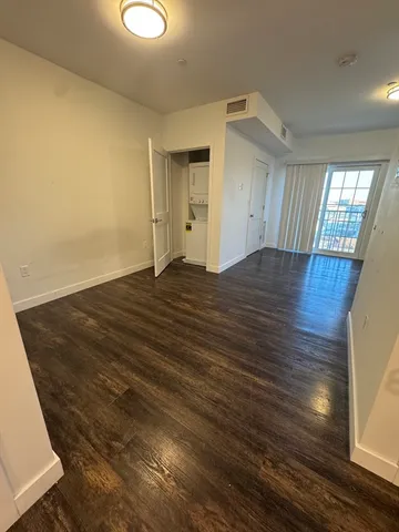 a view of empty room with wooden floor