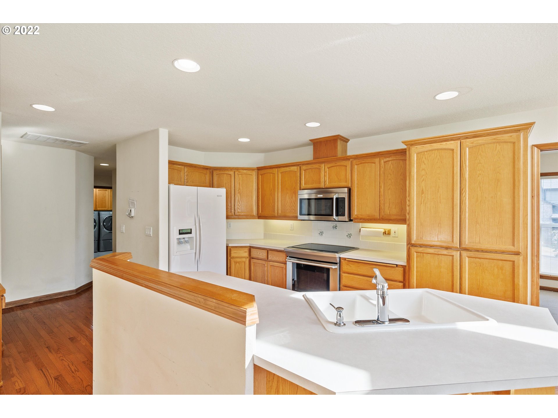 36930 Eldridge Drive Sandy, OR 97055 - Photo 18 of 32 a kitchen with stainless steel appliances kitchen island granite countertop a refrigerator a stove oven a sink with island and chairs