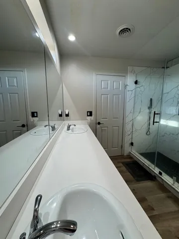a bathroom with a sink a toilet and shower