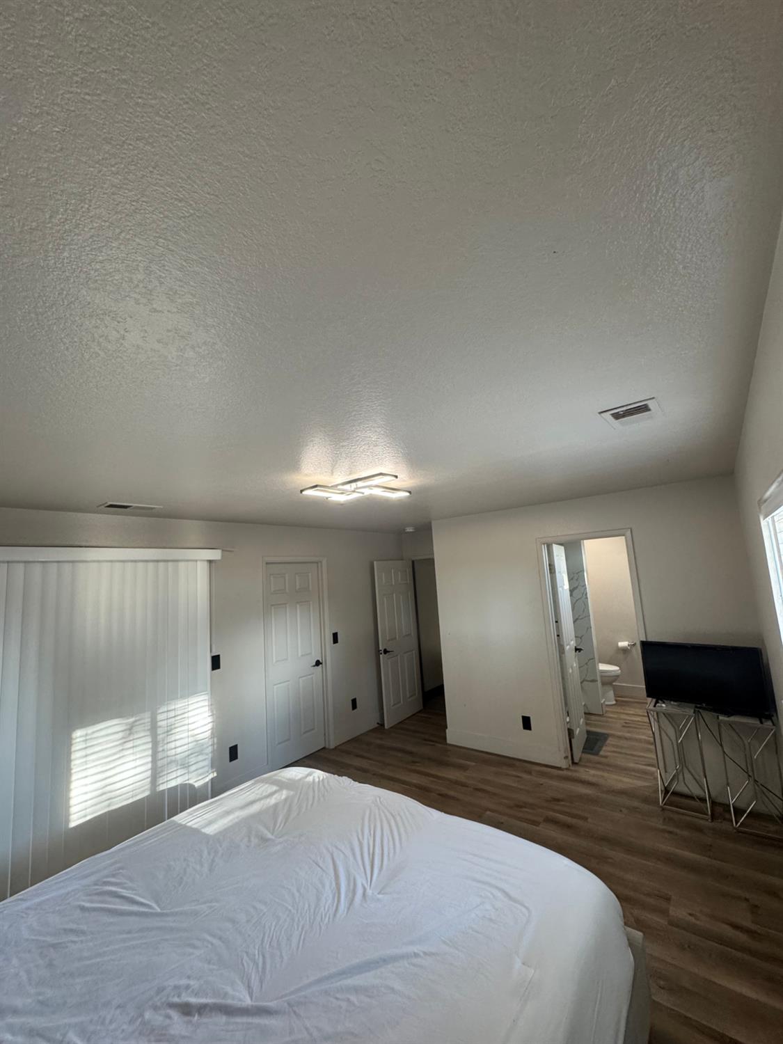 5931 Claribel Road Oakdale, CA 95361 - Photo 22 of 29 a large bedroom with a bed and a large window