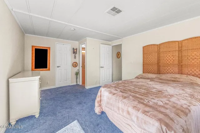 a bedroom with a large bed and a dresser