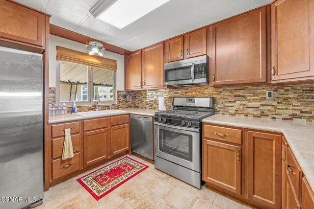 a kitchen with stainless steel appliances granite countertop a stove sink and cabinets
