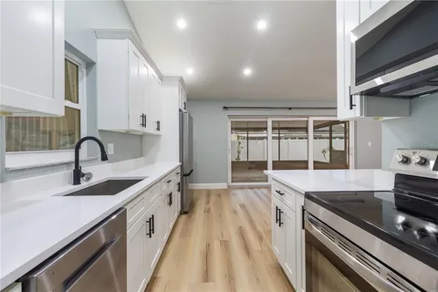 a kitchen with a sink stove and cabinets
