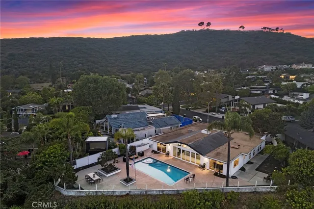 an aerial view of residential houses with outdoor space and trees