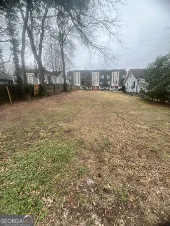 a view of house with yard and trees in the background