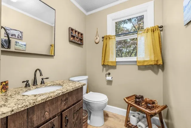 a bathroom with a granite countertop toilet sink and mirror