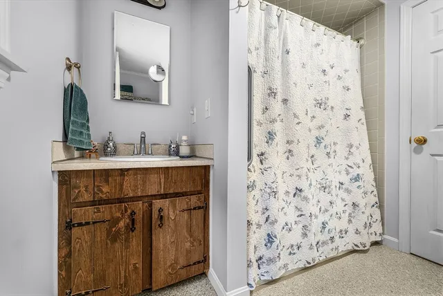 a bathroom with a sink a mirror a vanity and a shower