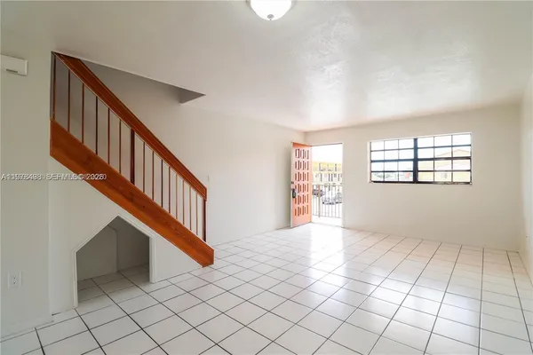 a kitchen with a stove a refrigerator and white cabinets