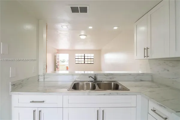 a kitchen with white cabinets and white appliances