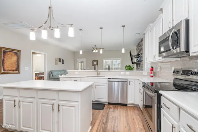 a kitchen with stainless steel appliances granite countertop a sink and stove top oven
