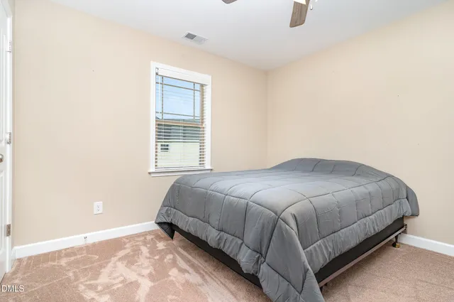 a bed sitting in a bedroom next to a window