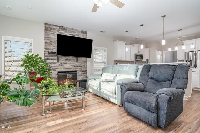 a living room with furniture a flat screen tv and a fireplace